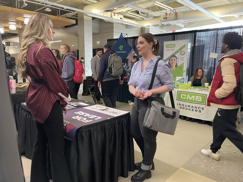 A student speaks to an exhibitor at the career fair